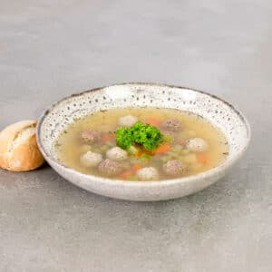 Færdiglavet klar suppe med urter og kødboller