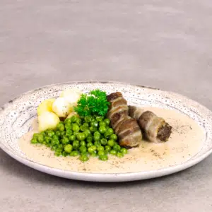 Okseruller med bacon, sauce, ærter og kartofler